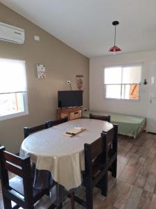 a dining room with a table and chairs and a bed at Casa Monte hermoso Barrio las Dunas in Monte Hermoso +1 photo