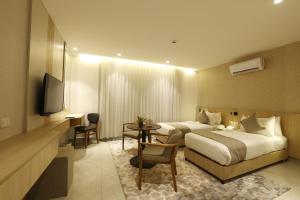 a hotel room with a bed and a table and a television at G Hotel Amman in Amman