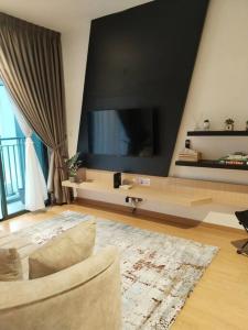 バンティングにあるIman RestHouse at Bandar Gamuda Coveのリビングルーム(ソファ、大画面テレビ付)