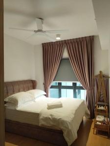 バンティングにあるIman RestHouse at Bandar Gamuda Coveの大きな窓のあるベッドのある寝室