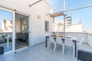 Un comedor con mesa y sillas en un balcón. en La Dolce Vista - Magaggiari, en Terrasini
