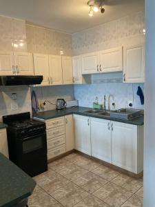 a kitchen with white cabinets and a sink and a stove at Margate Granada 404 in Margate +9 photos