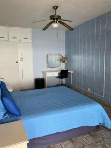 a bedroom with a blue bed and a ceiling fan at Margate Granada 404 in Margate