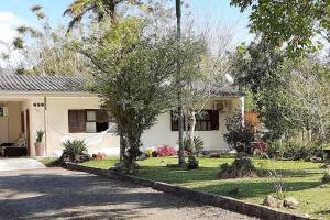 ein weißes Haus mit Bäumen im Hof in der Unterkunft Casa da Guia Canyons in Praia Grande