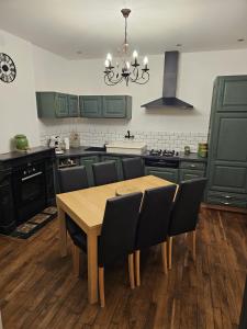 a kitchen with green cabinets and a wooden table and chairs at Chez Tantine in Troyes +6 photos