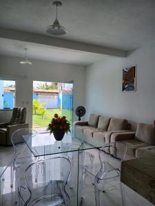 a living room with couches and a glass table at Casa de praia em Barra do Gil in Vera Cruz de Itaparica