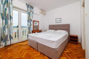 a bedroom with a large bed and a large window at AKELAVA in Crikvenica