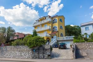 a yellow house with a fence in front of it at AKELAVA in Crikvenica