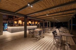 a restaurant with tables and chairs and a bar at Plakias Resorts in Plakias