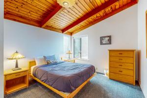 une chambre avec un lit et un plafond en bois dans l'établissement The Bobcat House, à Sea Ranch