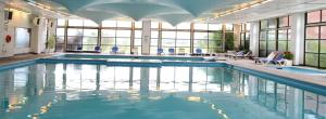 a large swimming pool with blue chairs and windows at RCT Club vacacional y Spa in General Conesa