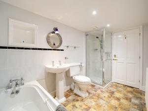 a bathroom with a toilet and a sink and a bath tub at Turtle Cottage in Charlestown +19 photos