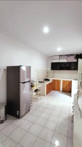 a kitchen with a stainless steel refrigerator and wooden cabinets at Kamiliya Homestay in Ngabean