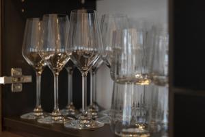 a row of wine glasses sitting on a shelf at josef's home I Superior Suite I Quiet & Central in Vienna +53 photos