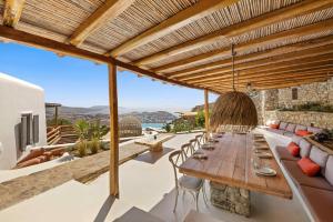 a patio with a long wooden table and chairs at Villa Maera 3 in Kalo Livadi