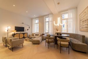a living room with a couch and a table and chairs at josef's home I Superior Suite I Quiet & Central in Vienna