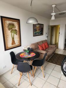 a living room with a table and a couch at Apezinho da Soltony em Peruibe in Peruíbe