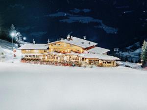 un gran edificio en una pista de esquí en la nieve en Alpengasthof Hochsöll, en Söll