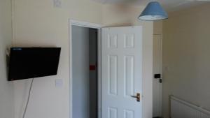 a room with a door and a tv on a wall at The White Hart Inn in Tetford