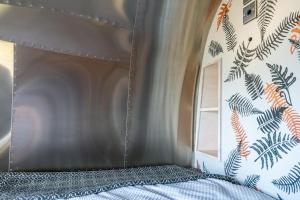 un dormitorio con una cama y una ventana en Airstream - Seabreeze Airstream Overlander in Pembrokeshire, en Haverfordwest