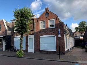 a brick house with two garage doors on a street at Luxury 6pers appartement Abcoude in Abcoude