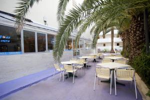 een rij tafels en stoelen voor een restaurant bij BJ Hostal Bona Vista in S'Illot