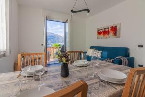 a dining room with a table and chairs and a window at Sweet Caroline in Lierna