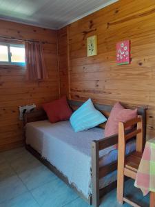 ein Schlafzimmer mit einem Bett in einer Holzhütte in der Unterkunft Itsasoa in Barra del Chuy