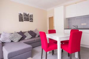 a living room with a white table and red chairs at Ilot de paix in Ostend