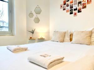 a bedroom with a white bed with towels on it at Le Saint Roch - Hyper Centre - Clim - Cosy - Rénové in Mont-de-Marsan