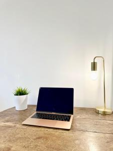 a laptop computer sitting on top of a wooden table at Le Saint Roch - Hyper Centre - Clim - Cosy - Rénové in Mont-de-Marsan