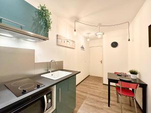 a kitchen with a sink and a table at Le Saint Roch - Hyper Centre - Clim - Cosy - Rénové in Mont-de-Marsan +41 photos