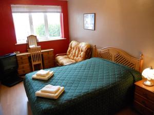 a bedroom with a green bed with two towels on it at The Gordon in Scarborough