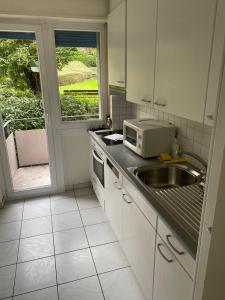 una cocina con fregadero y microondas en 2BR near city center - Vineyard 21, en Zúrich