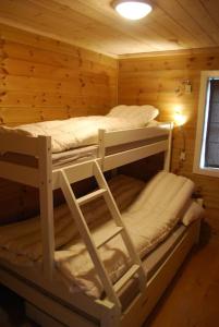 two bunk beds in a log cabin at Flott hytte på Smølåsen Tjørhom in Fidjeland