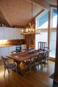 a dining room with a large wooden table and chairs at Flott hytte på Smølåsen Tjørhom in Fidjeland