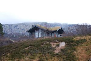 an old house on top of a hill at Flott hytte på Smølåsen Tjørhom in Fidjeland
