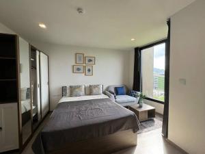 a bedroom with a large bed and a couch at The Base Central Phuket in Phuket +25 photos