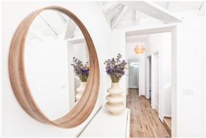 a mirror in a hallway with flowers in a vase at Casa Nieves, vistas únicas y tranquilidad in San Andres y Sauces