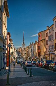 a city street with a clock tower in the distance at Le Cosy Shelby Proche gare 150m in Villefranche-sur-Saône