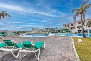 Un patio con tumbonas y una piscina. en Sarelen 3, paz y excelente ubicación, en Breña Baja