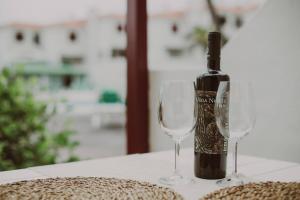 Una botella de vino y dos copas de vino en una mesa en Sarelen 3, paz y excelente ubicación, en Breña Baja 8 fotos más