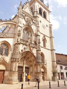 zwei Menschen, die vor einer Kathedrale laufen in der Unterkunft Le Cosy Express in Villefranche-sur-Saône