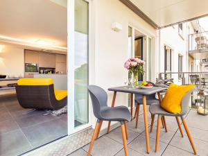 einen Balkon mit einem Tisch und Stühlen sowie eine Küche in der Unterkunft FeWo Prora - GiGi in Binz
