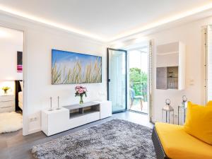ein weißes Wohnzimmer mit gelber Couch in der Unterkunft FeWo Prora - GiGi in Binz + 12 Fotos