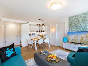 ein Wohnzimmer mit einer blauen Couch und einem Tisch in der Unterkunft FeWo Prora - PRORA week in Binz