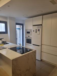 a kitchen with a white refrigerator and a stove at Ap Skerup Calpe City cerca Playa in Calpe