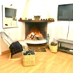 Una sala de estar con chimenea y televisión. en VILLA HUETOR , Piscina y barbacoa privada, en Huétor Vega