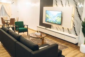 a living room with a couch and a tv at 505 Apartment by Wetland Hotel in Warri