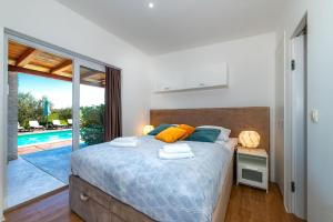 a bedroom with a bed with a view of a pool at Villa Almond in Nin +50 photos